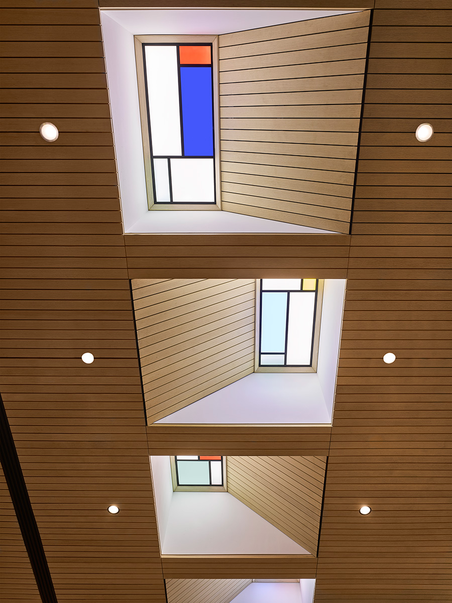 Illuminated ceiling coffers, inspired by stained-glass windows, brighten the room and give the appearance of skylights